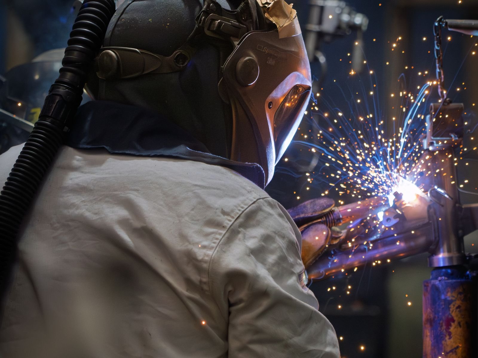 Sheet metal fabrication shop in operation, welding sparks and metalwork in progress